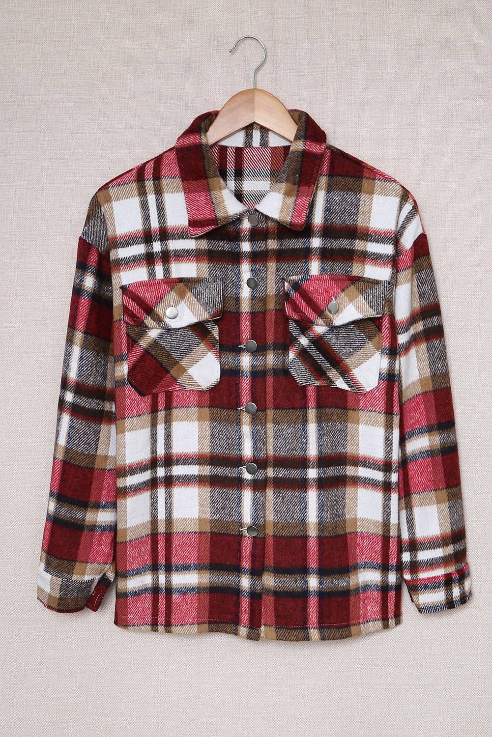 Plaid shirt on a hanger against a plain background