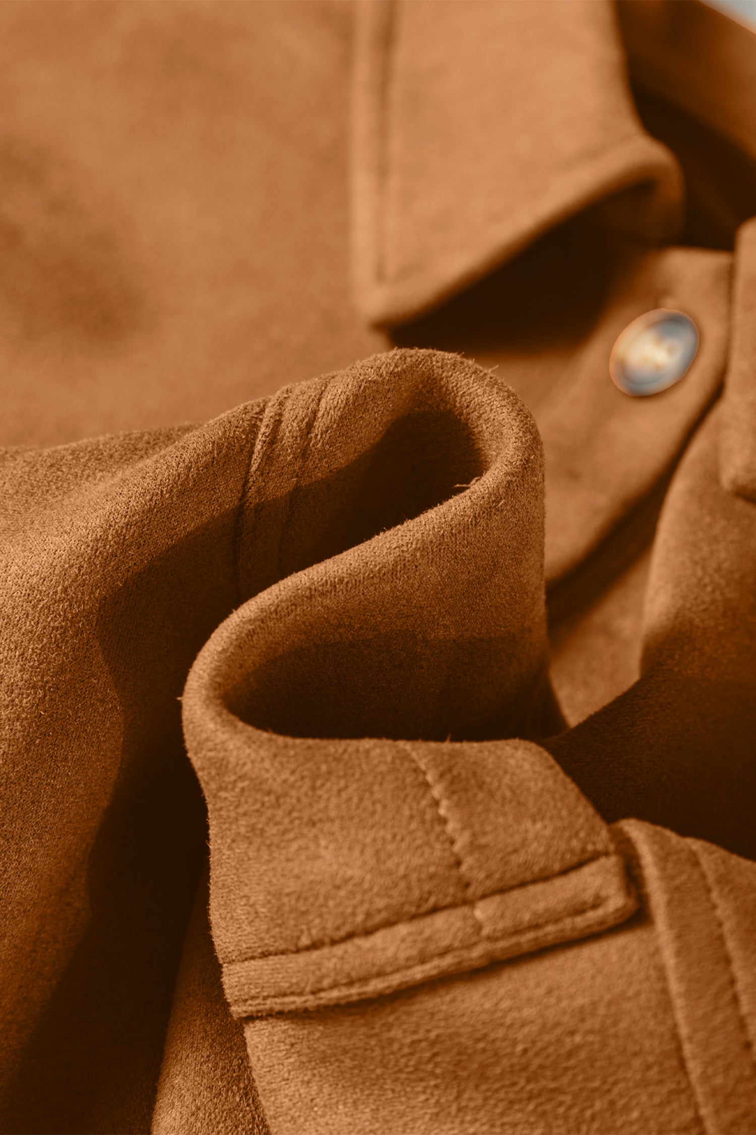 Close-up of a brown coat with a button