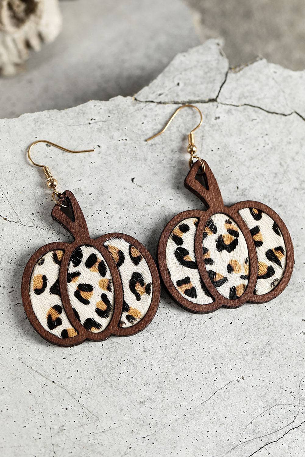 Leopard print pumpkin earrings on a textured surface