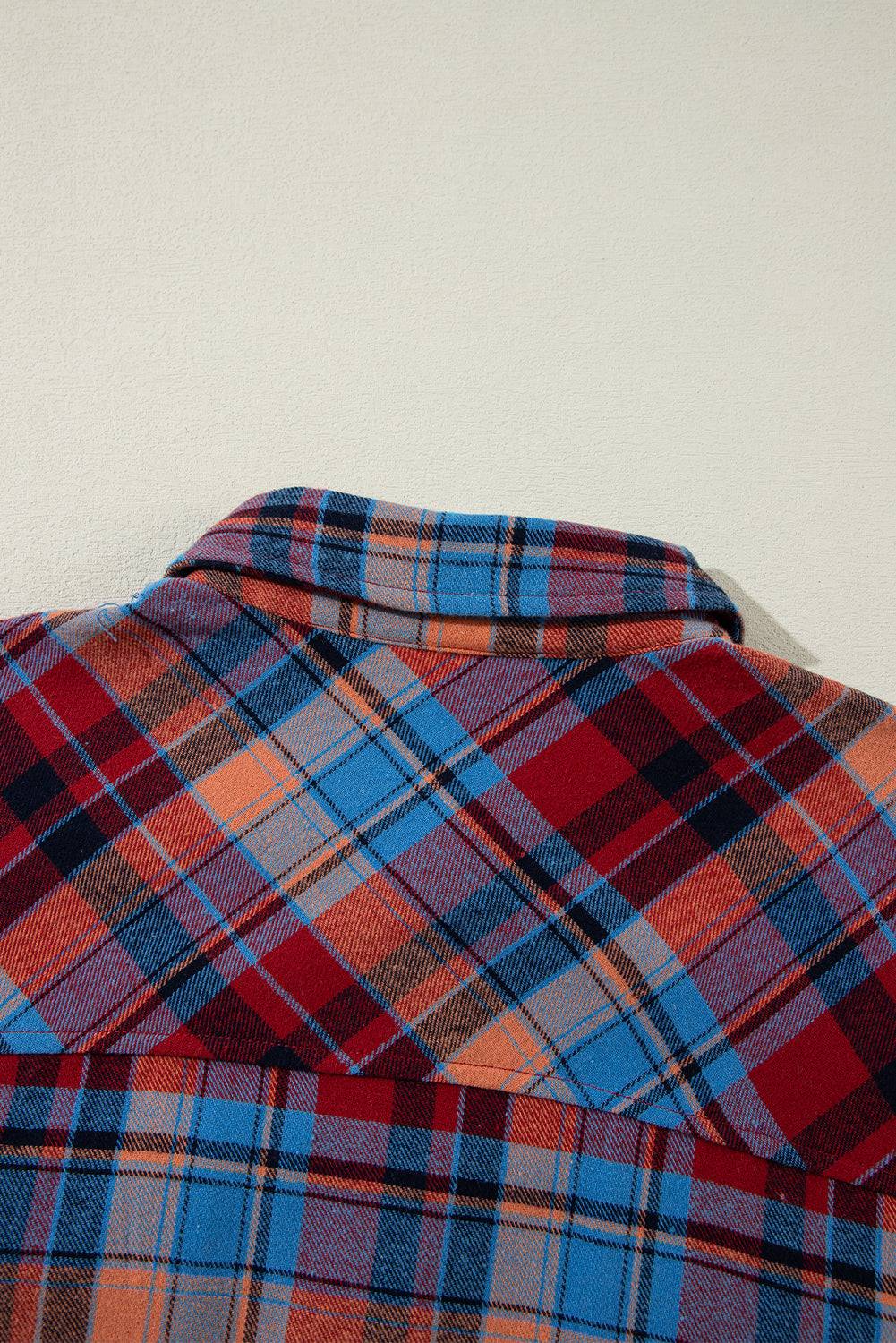 Close-up of a plaid shirt with red, blue, and orange patterns  