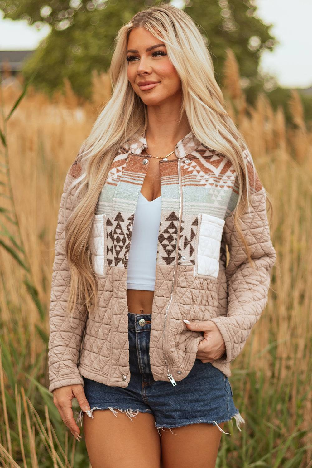 Woman wearing a patterned jacket in a field